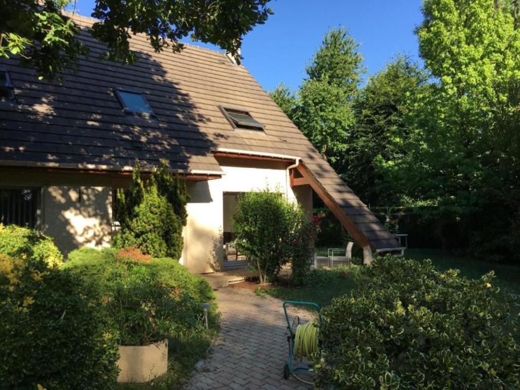 een huis met een bankje ervoor bij Maison Chevreuse, chambre chez l'habitant in Magny-les-Hameaux