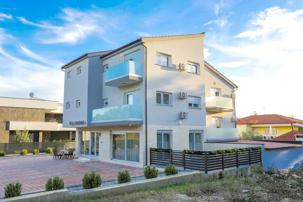 un gran edificio blanco con patio en Villa Astoria, en Biograd na Moru