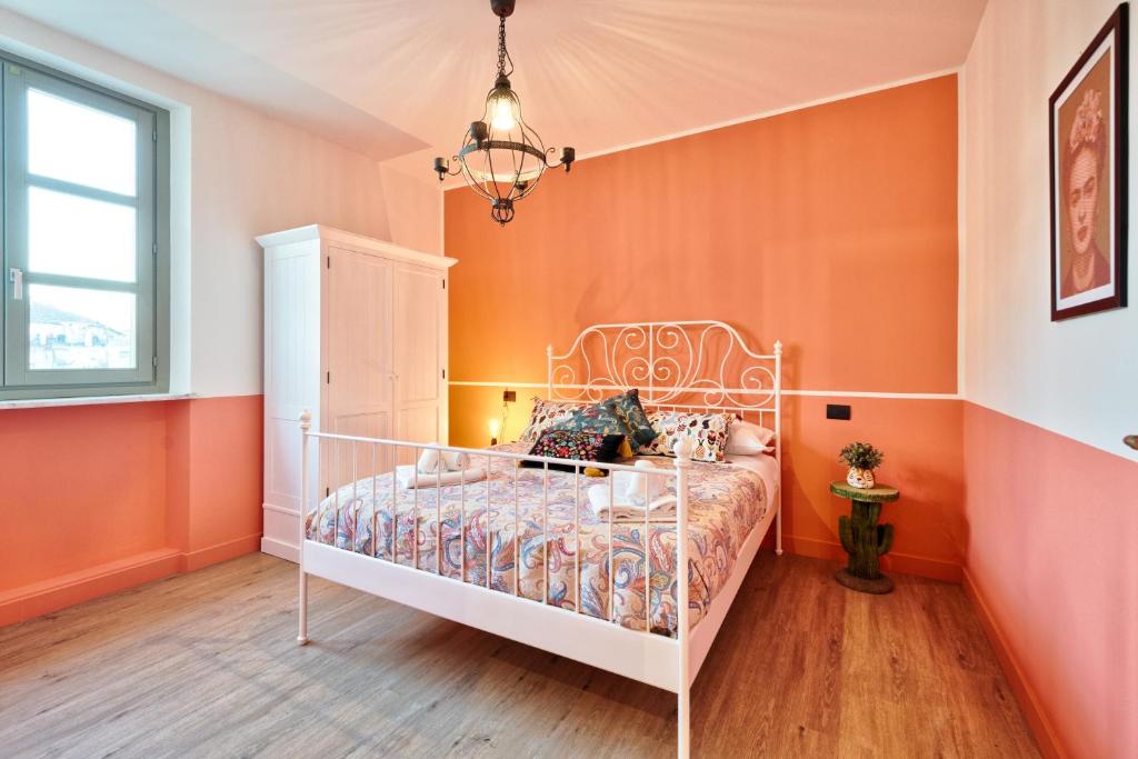 sypialnia z łóżkiem z pomarańczową ścianą w obiekcie La casa del Mercato - Design Apartment w Turynie