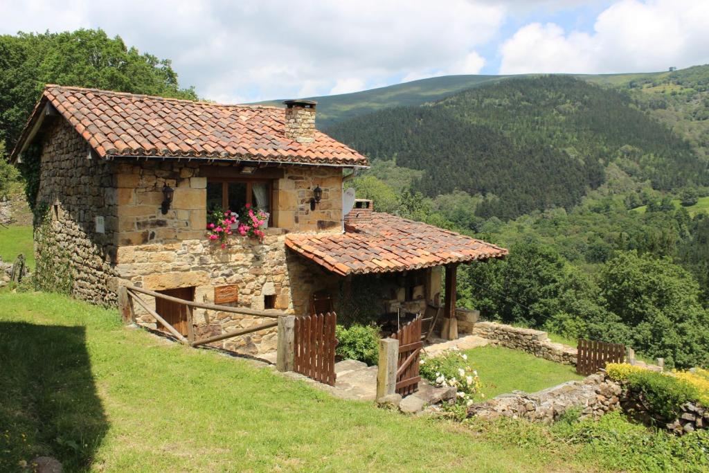 una vieja casa de piedra al lado de una colina en El Refugio de Luena en San Miguel de Luena