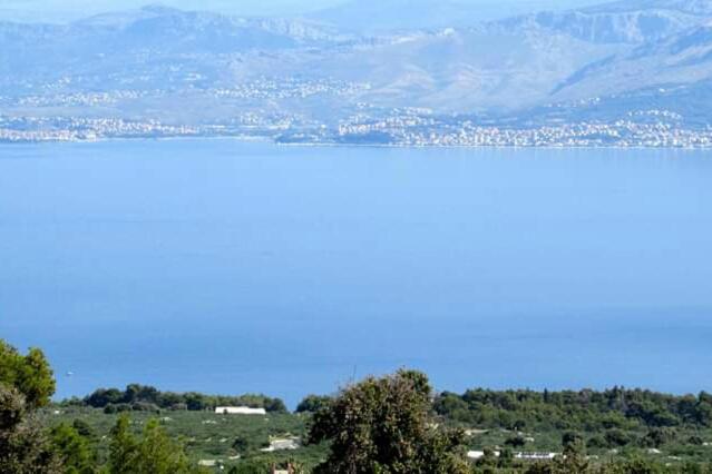 uma vista para um campo com árvores e montanhas em Camping Brizi em Supetar