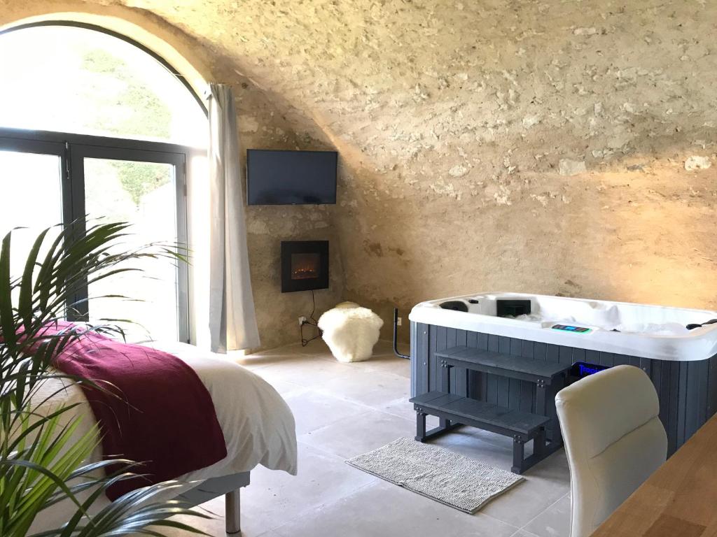 a bathroom with a tub in a room with a window at Paradise Love In Provence - loft en pierres - spa privatif in Reillanne