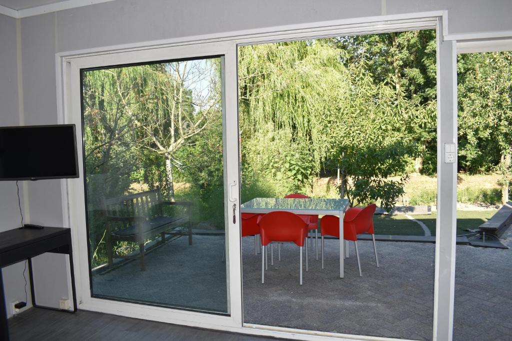 una puerta corredera de cristal que da a un patio con mesa y sillas en Den Laage hof, en Heusden