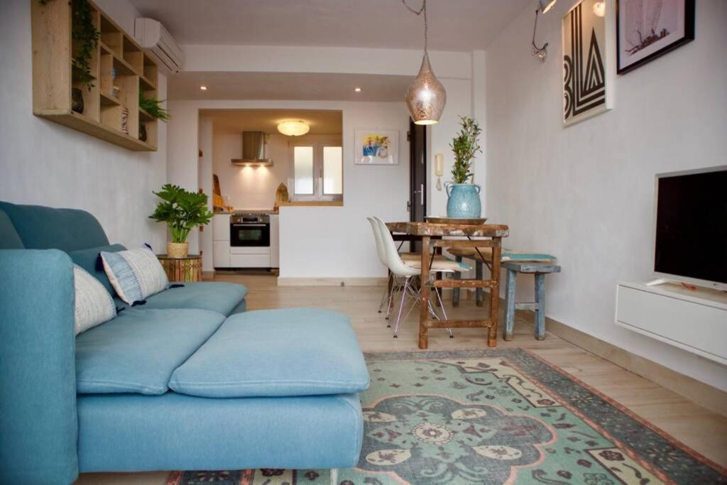un soggiorno con divano blu e tavolo di Javea luxury apartment 50m from Arenal sandy beach a Jávea