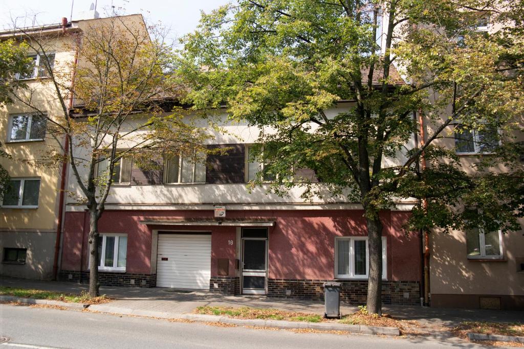 a red building with a white garage at Penzion Hlinkova in Pilsen