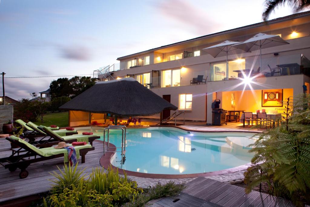 a swimming pool in front of a house at Lala Panzi B&B in Plettenberg Bay