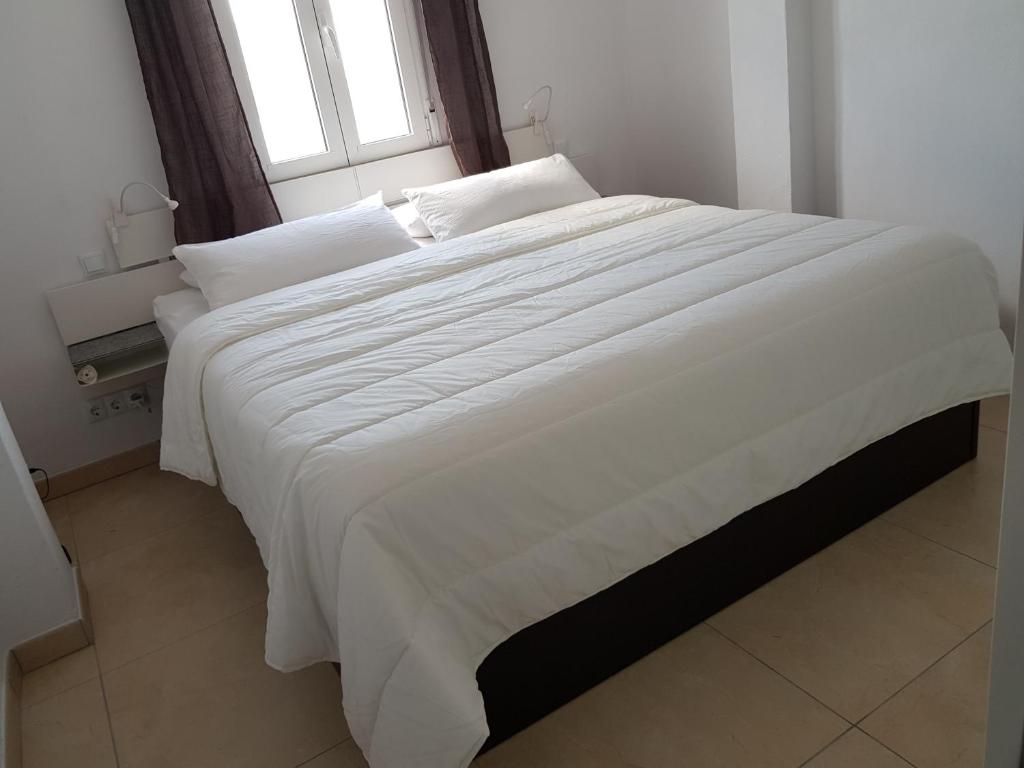 甘迪亚Exclusive Apartment - Playa de Marenys de Rafalcaid的带窗户的房间里有一张白色的大床