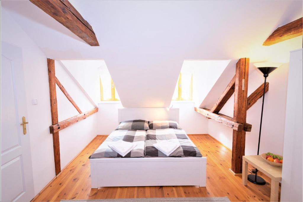 een slaapkamer met een bed in een kamer met houten vloeren bij Rodinný pension Bečov in Bečov nad Teplou