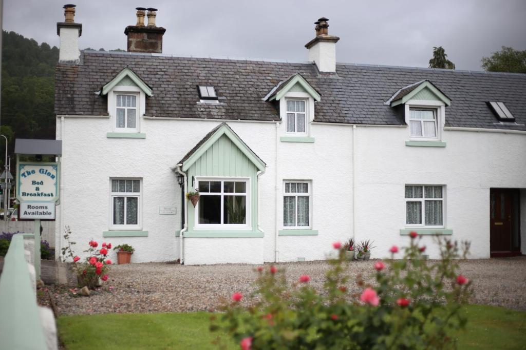 a white house with flowers in front of it at The Glen Bed and Breakfast in Drumnadrochit