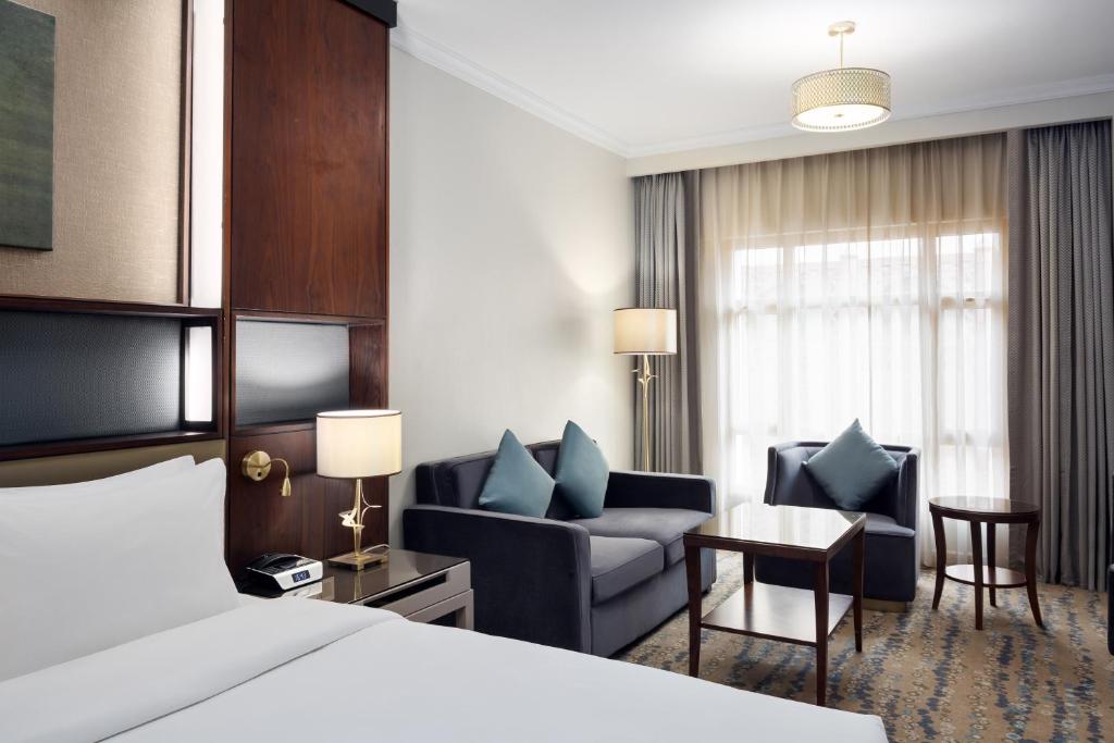 a hotel room with a bed and a living room at Saja Al Madinah in Al Madinah