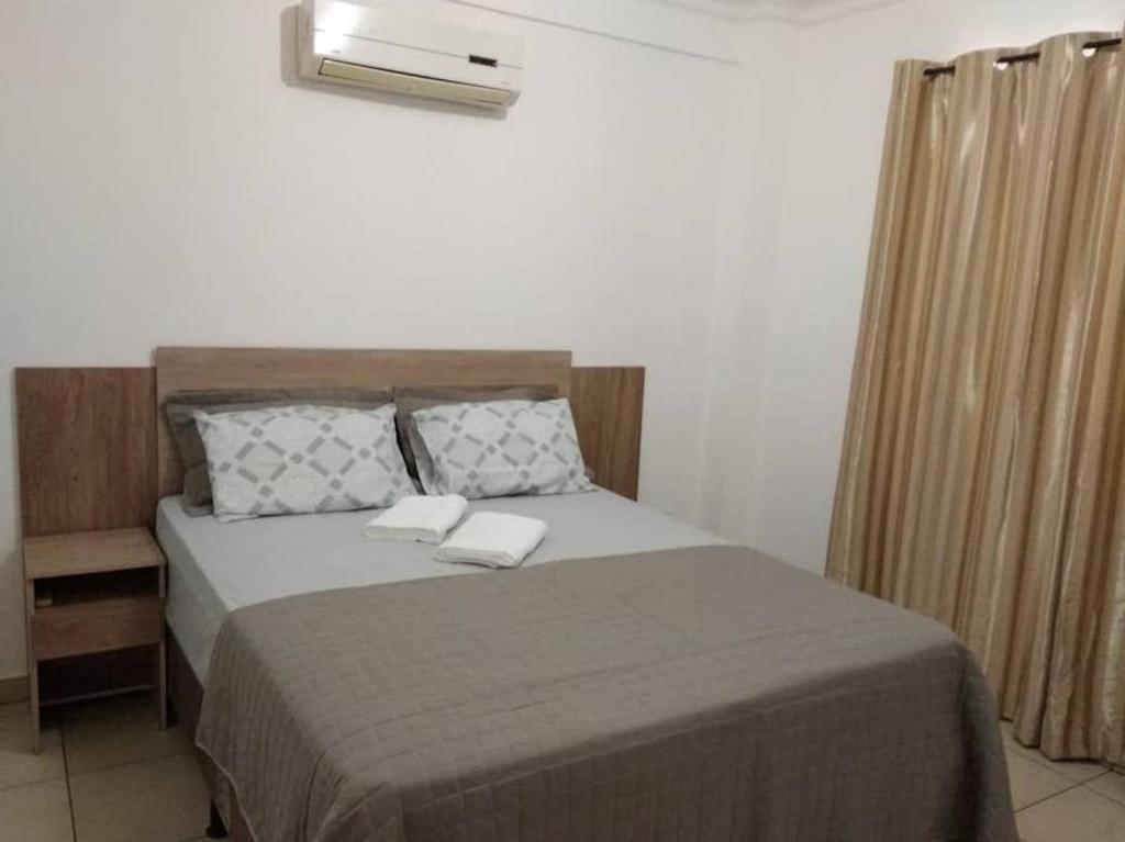 a bedroom with a bed with two towels on it at Apartamento Cidade Verde 4 MT in Maringá