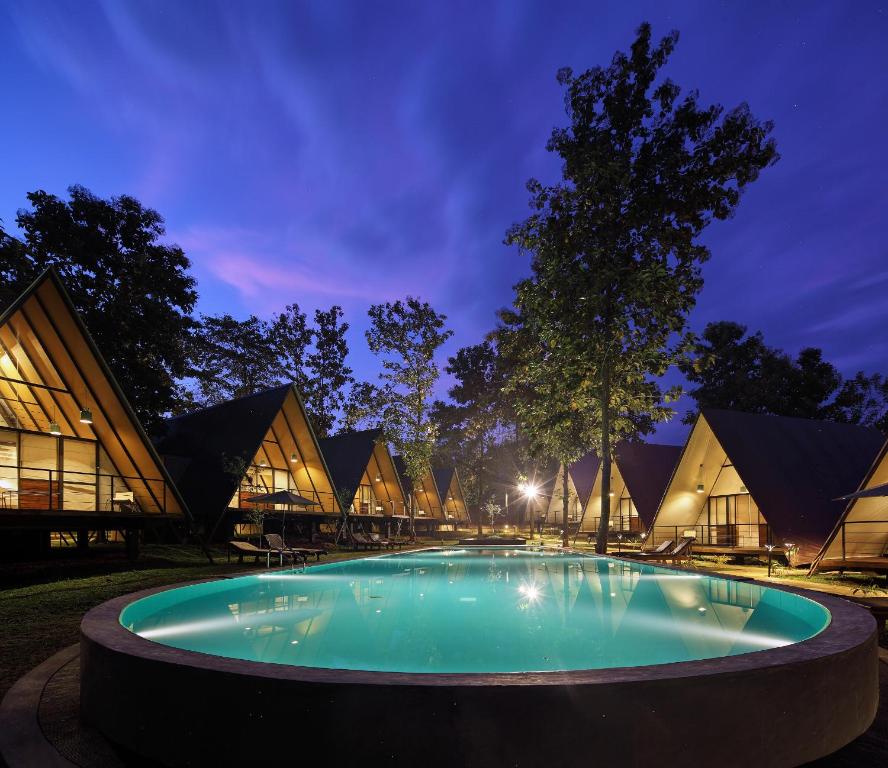 a swimming pool in front of a building at night at Kottawatta River Bank Resort in Udawalawe