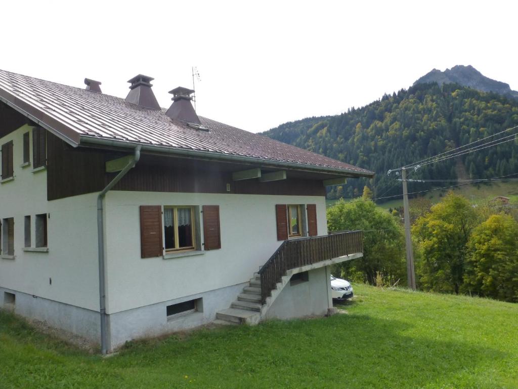 een wit huis met een veranda en een trap bij Le Fayet d'en haut in Abondance