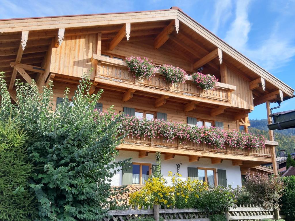een gebouw met een balkon met bloemen erop bij Haus Egger in Reit im Winkl