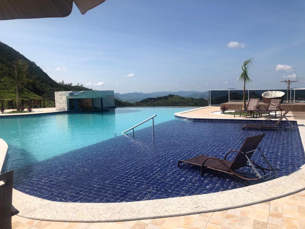 uma piscina com duas espreguiçadeiras em Fazenda Morro Pelado em Águas de Lindoia