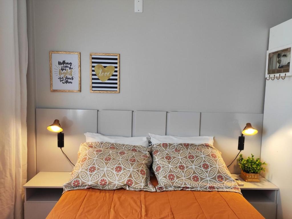 een slaapkamer met een bed met 2 lampen en 2 kussens bij Apto 3 quartos em Araranguá in Araranguá
