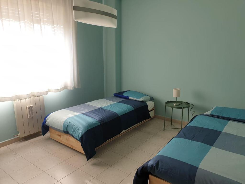 sypialnia z dwoma łóżkami i oknem w obiekcie COCO Apartments w Katanii