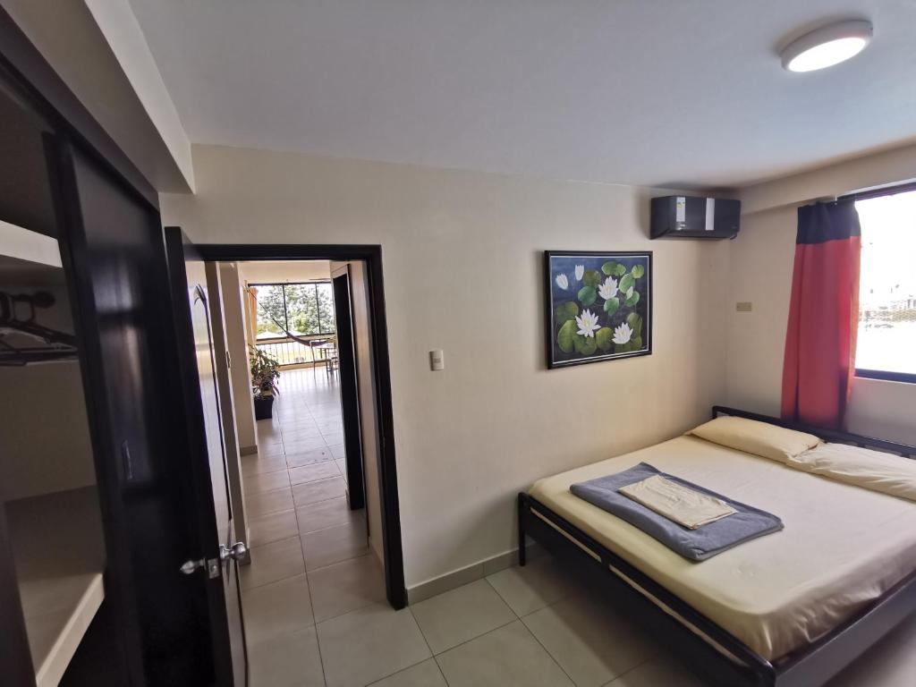 ein kleines Schlafzimmer mit einem Bett in einem Zimmer in der Unterkunft Blue Ocean Apartments Chipipe in Salinas