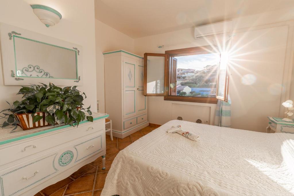 una camera con letto bianco e specchio di Poggio dei fiori a Olbia