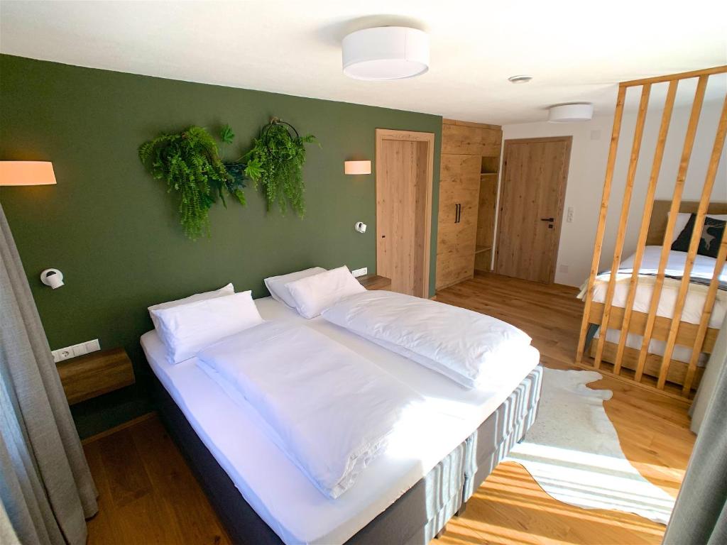 un grande letto in una stanza con parete verde di Chalet See Tirol - Ischgl/Kappl a See