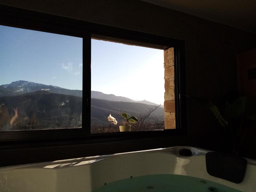 eine Badewanne im Bad mit 2 Fenstern in der Unterkunft Gites du pech cathare in Leychert