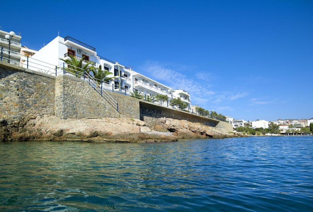 a building on the side of a body of water at Victoria Hotel in Agios Nikolaos