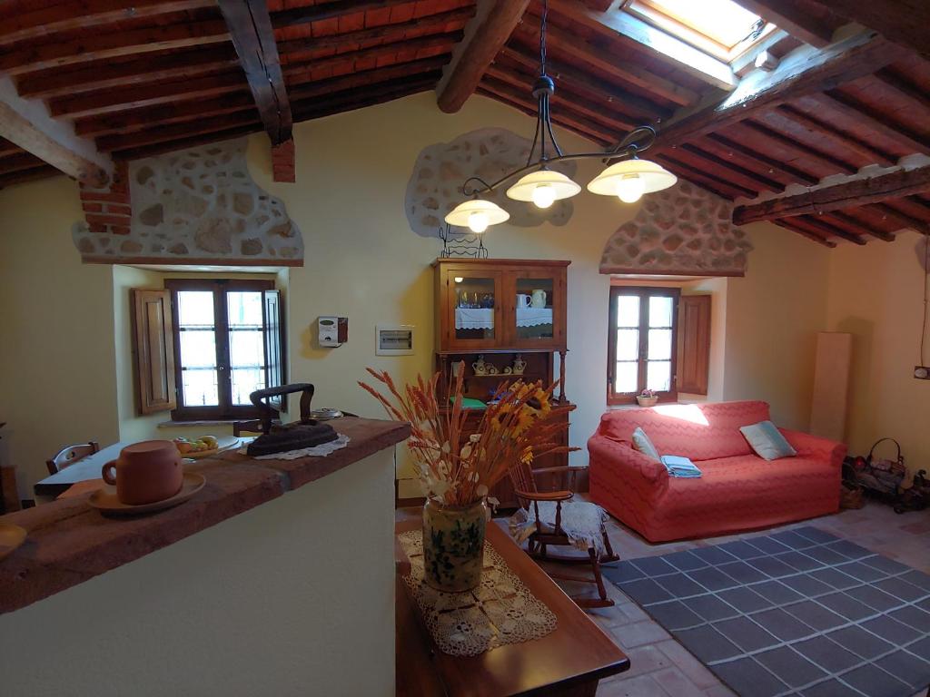salon z czerwoną kanapą w pokoju w obiekcie Casina nel Borgo w mieście Pari