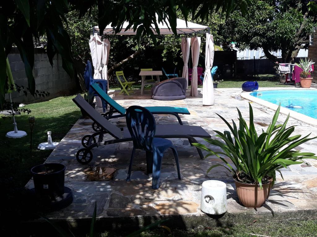 einen Pool mit einem Stuhl, einem Tisch und einem Pool in der Unterkunft villa do brazil in Ducos