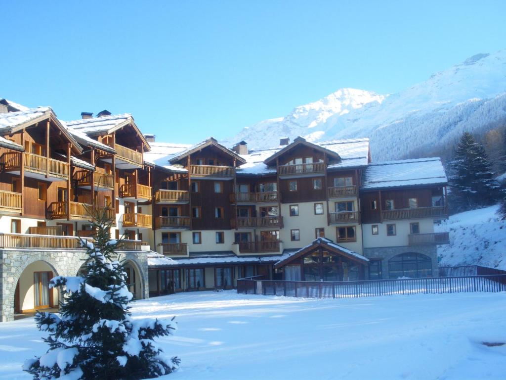 a ski lodge in the snow with a christmas tree at Les Alpages De Val Cenis by Resid&amp;co in Lanslebourg-Mont-Cenis