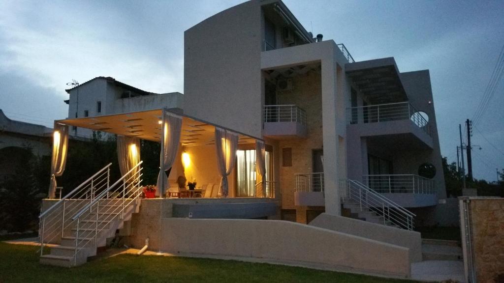 a large white house with stairs in front of it at VILLA BY THE SEA VRAVRONA LOUTSA(NEAR THE AIRPORT&METROPOLITAN) in Athens