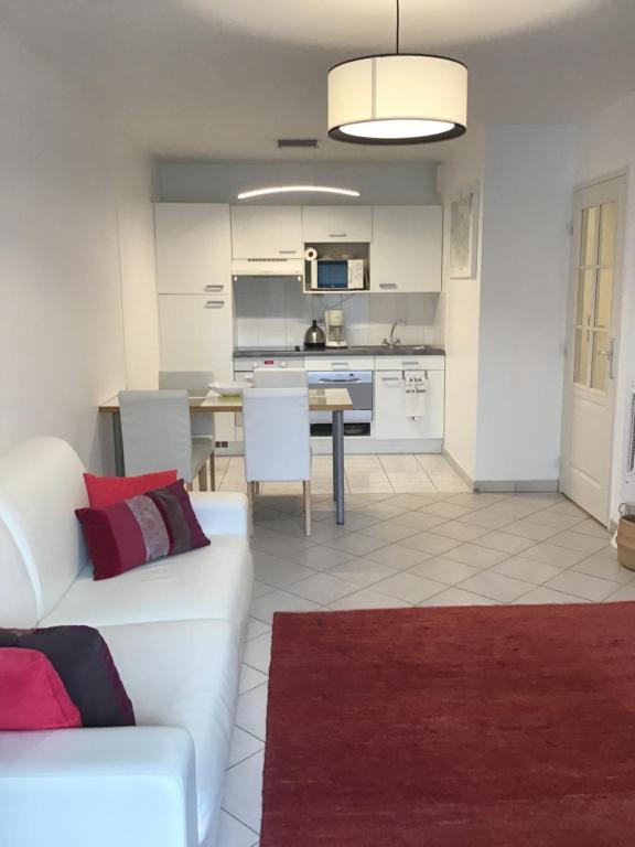 Il comprend un salon avec un canapé blanc et une cuisine. dans l'établissement Escale A L Amiraute, à Saint-Valery-sur-Somme