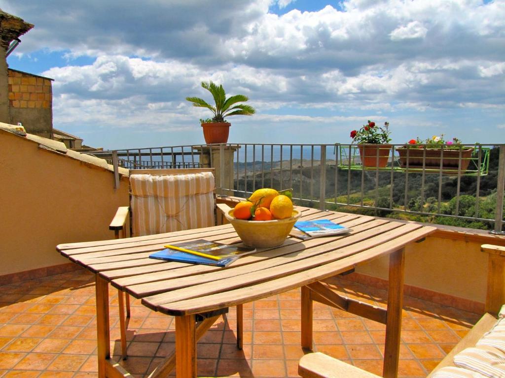 a wooden table with a bowl of fruit on a balcony at Slow holidays in Calabria tradizioni eno-gastonomia tra borgo e mare in Badolato