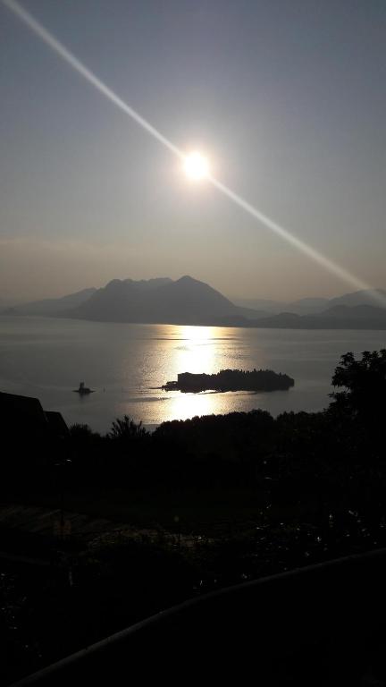 a sun setting over a large body of water at La Corte di Nonno Gino in Stresa