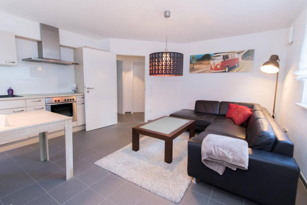 un soggiorno con divano e tavolo di Appartement Neuenstadt in ruhiger Lage im Wohngebiet a Neuenstadt am Kocher