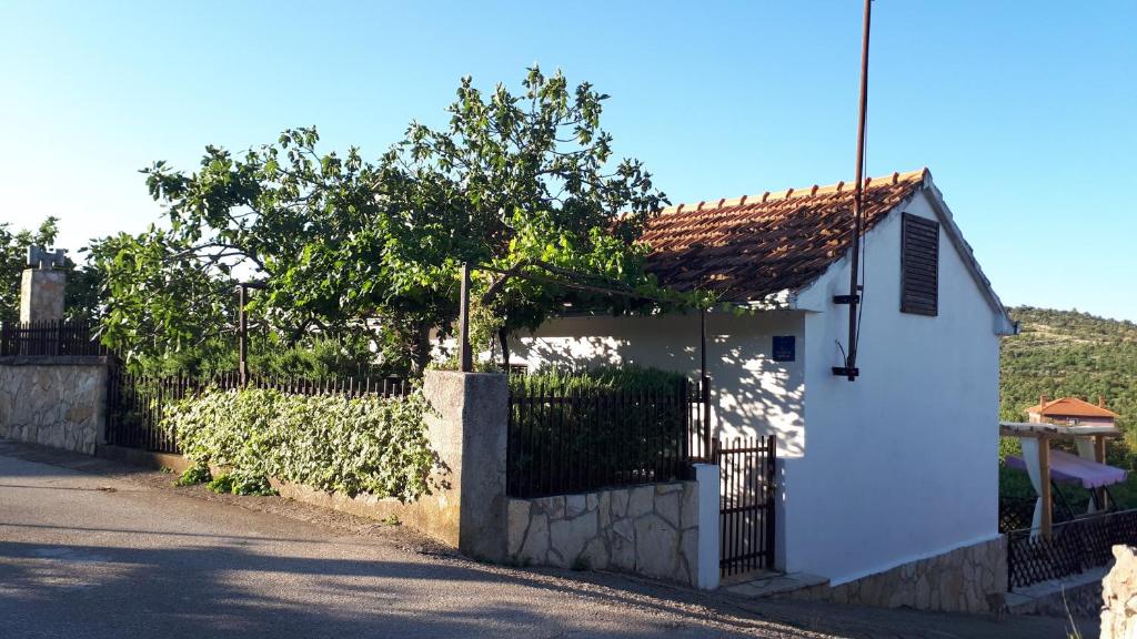 una casa blanca con una puerta y una valla en Luminaria Solis Vacation Home, en Rogoznica