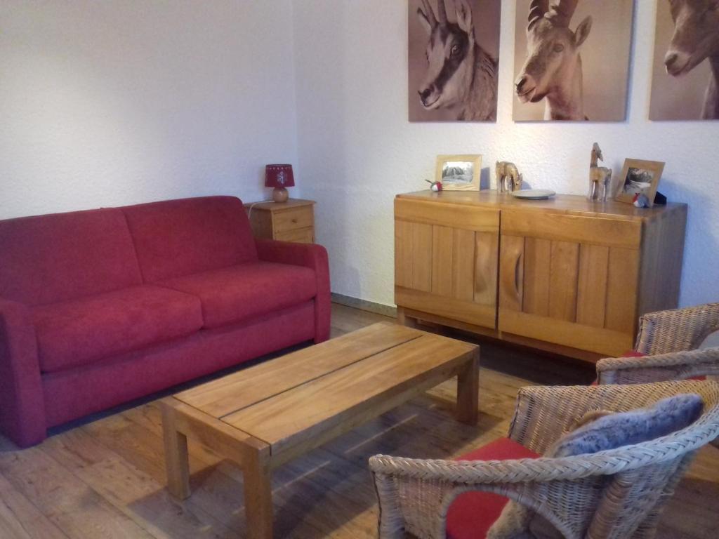 - un salon avec un canapé rouge et une table basse dans l'établissement 2 Alpes-locations Studio 4 personnes, à Les Deux Alpes