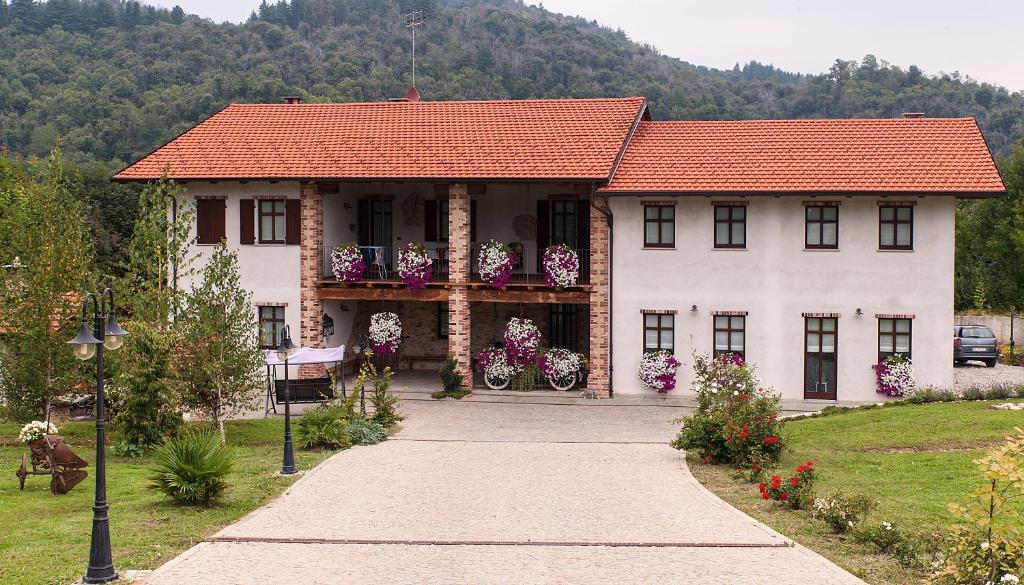 a large white house with a red roof at Ciabot Besimauda in Peveragno