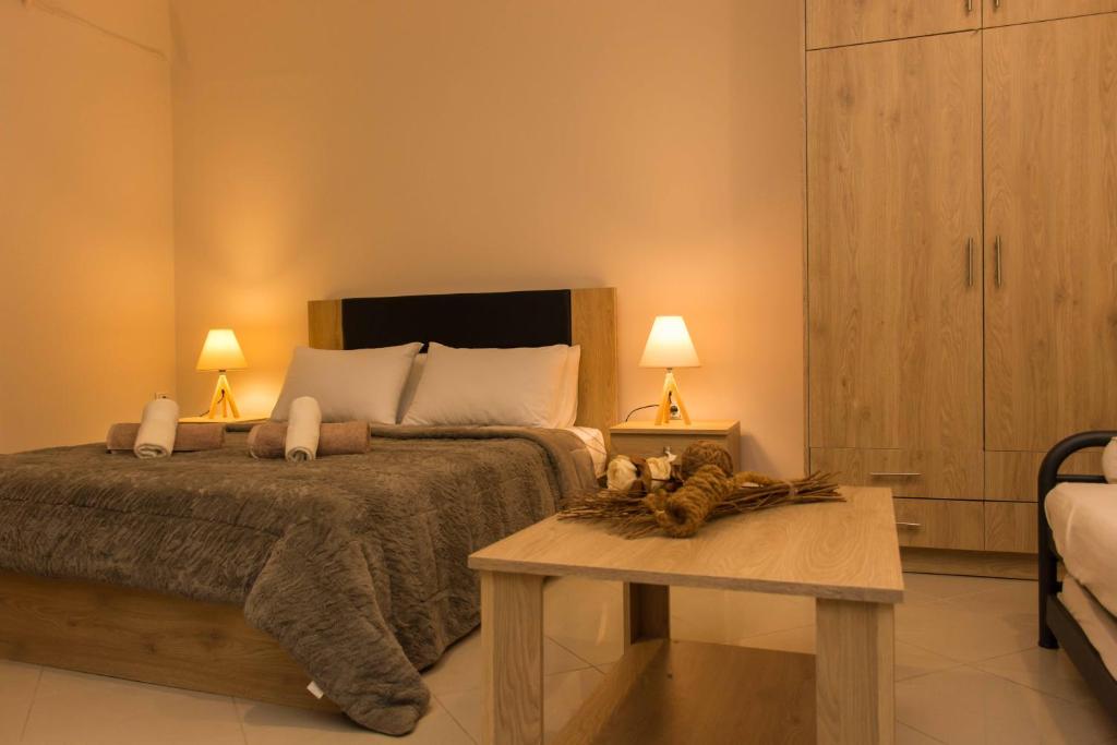 a bedroom with a bed with a table and two lamps at Central Luxury Studio in Korinthos