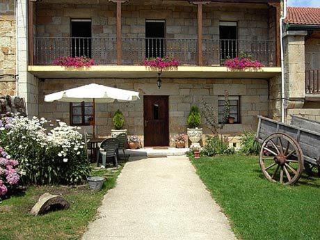 ein Haus mit einem Tisch und einem Sonnenschirm im Hof in der Unterkunft Hotel Rural El Rincón de Gadea in Santa Gadea