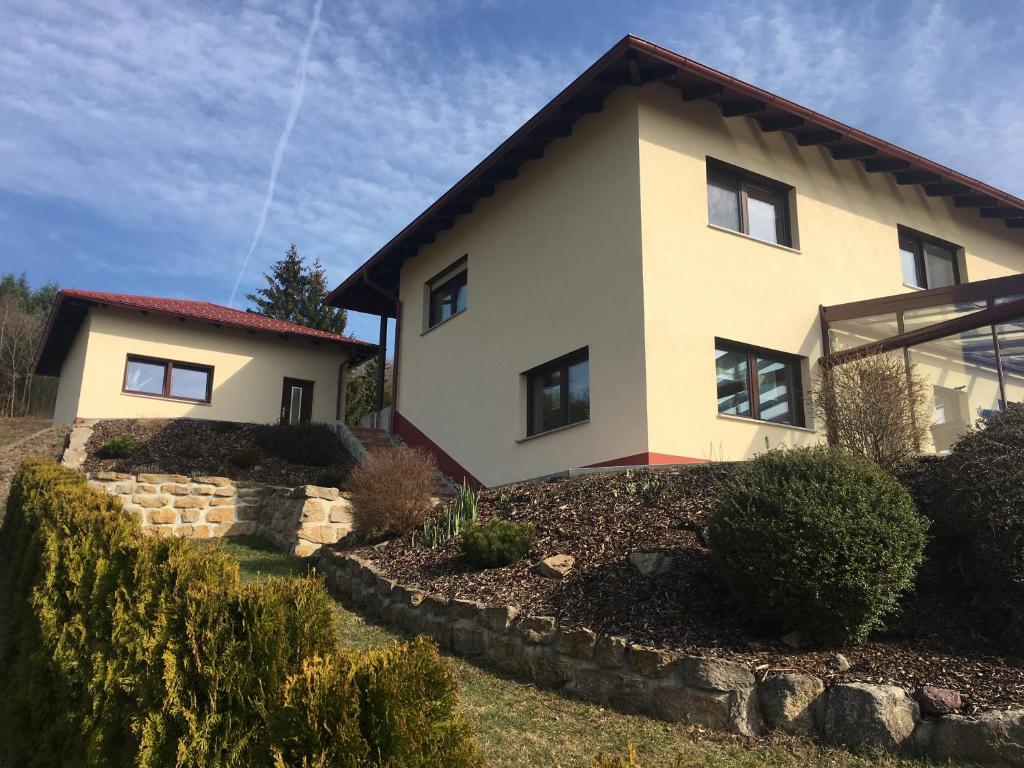 a house with a stone wall in front of it at Haus Am Wald in Wasungen