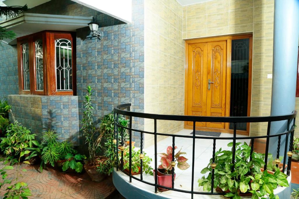 ZuriEL Suite GUEST HOUSE في كويمباتور: منزل فيه مجموعه من النباتات امام باب