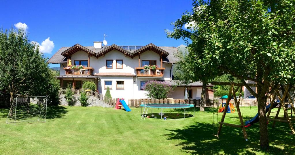 une maison avec une cour dotée d'une table et d'une aire de jeux dans l'établissement Appart Gfall, à Ried im Oberinntal