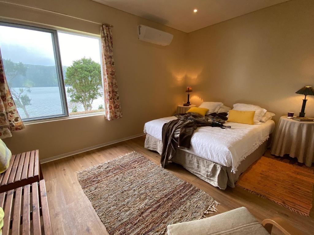 1 dormitorio con 2 camas y ventana grande en Lake Cottage - Panoramic views 7 Cidades en Sete Cidades