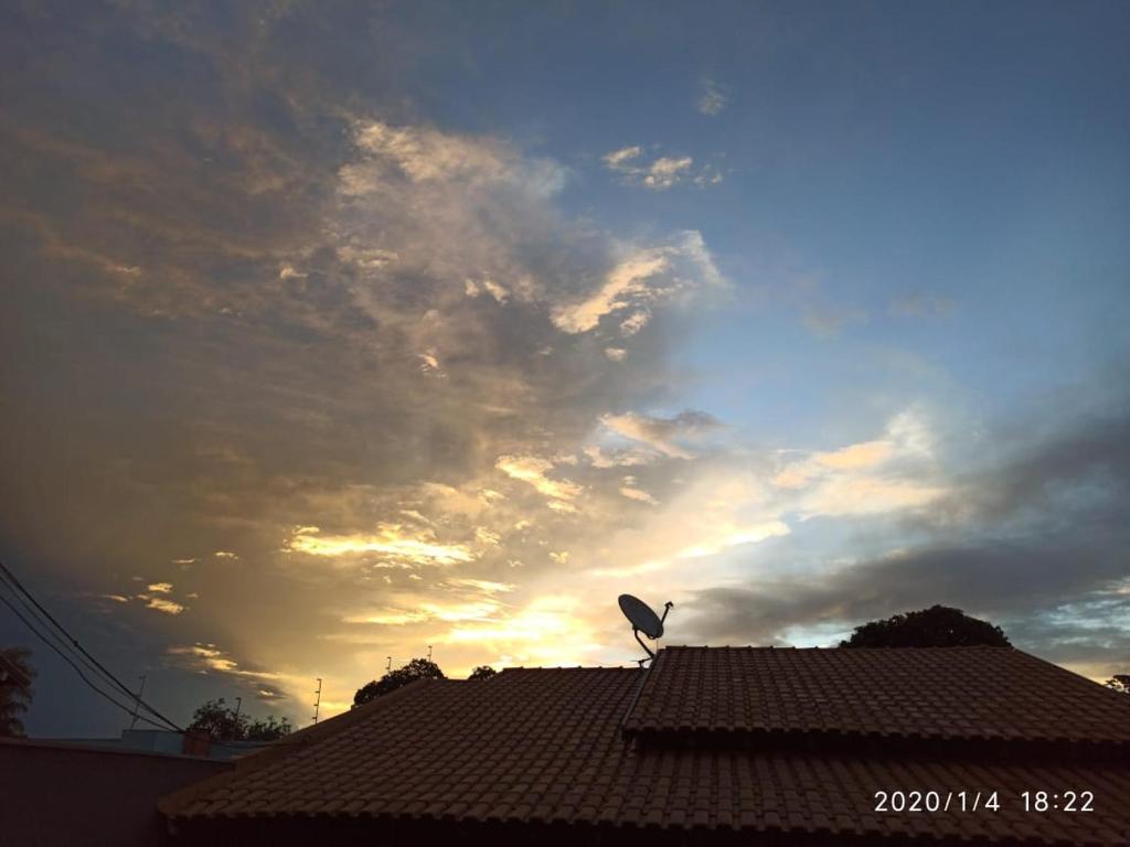 ein Vogel auf einem Dach mit wolkigem Himmel in der Unterkunft DOURADOS GUEST FLAT HOUSE in Dourados