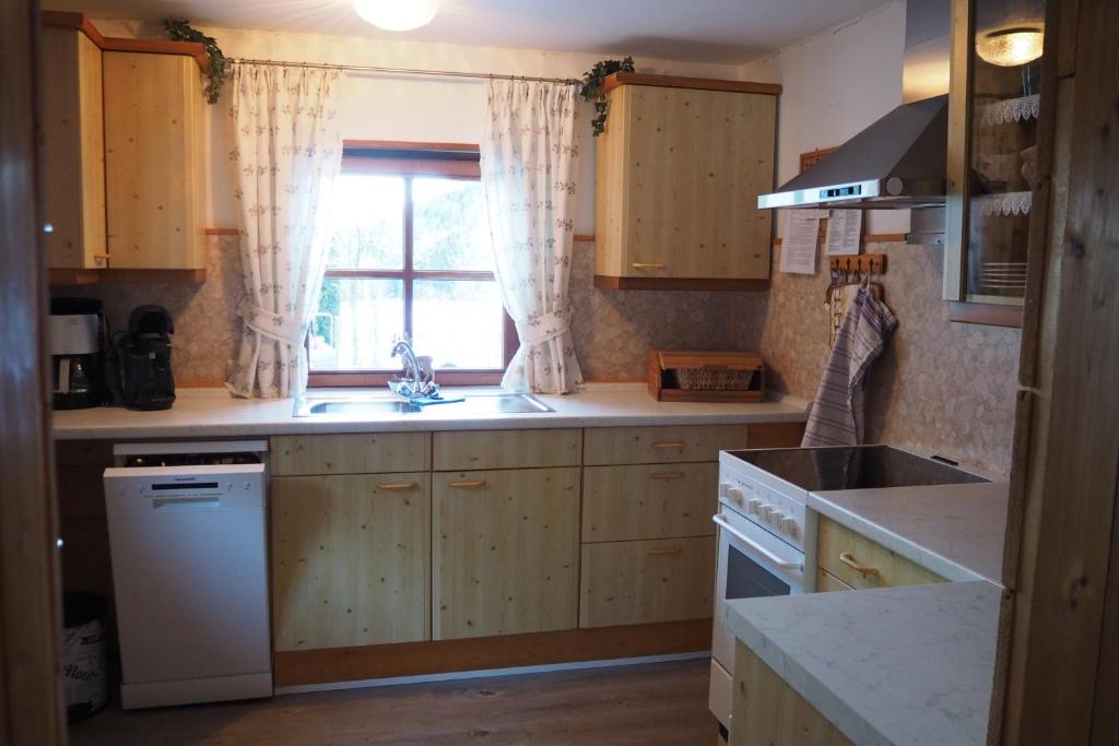 a kitchen with wooden cabinets and a sink and a window at Ferienhütte in Ruhpolding in Ruhpolding
