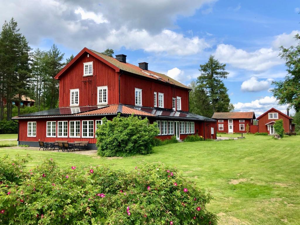 a large red barn with white windows on a field at THE LODGE Torsby in Torsby