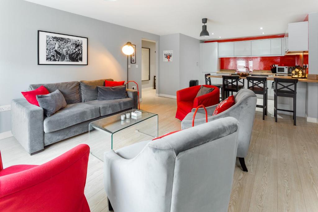 a living room with couches and red chairs and a kitchen at Centrally located apartment in Duke Street- free parking- two bathrooms in Liverpool