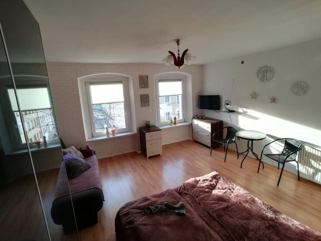 a living room with a bed and a table and chairs at JULIUSZ in Lądek-Zdrój