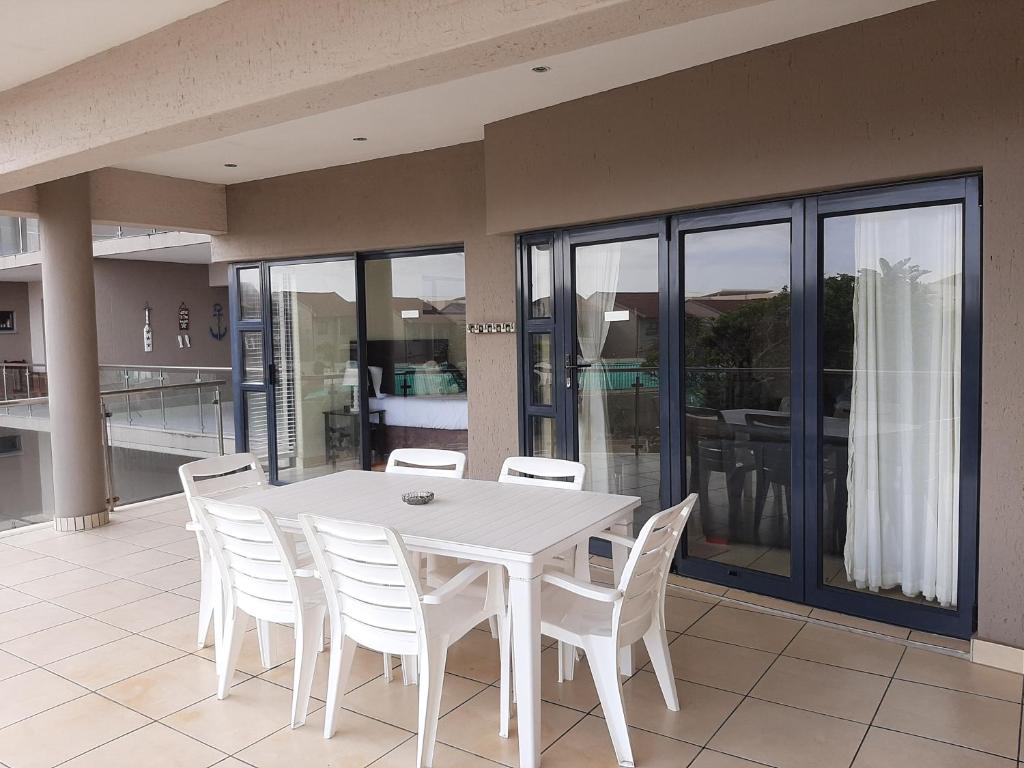 a white dining room table and chairs on a patio at Whale Rock in Margate