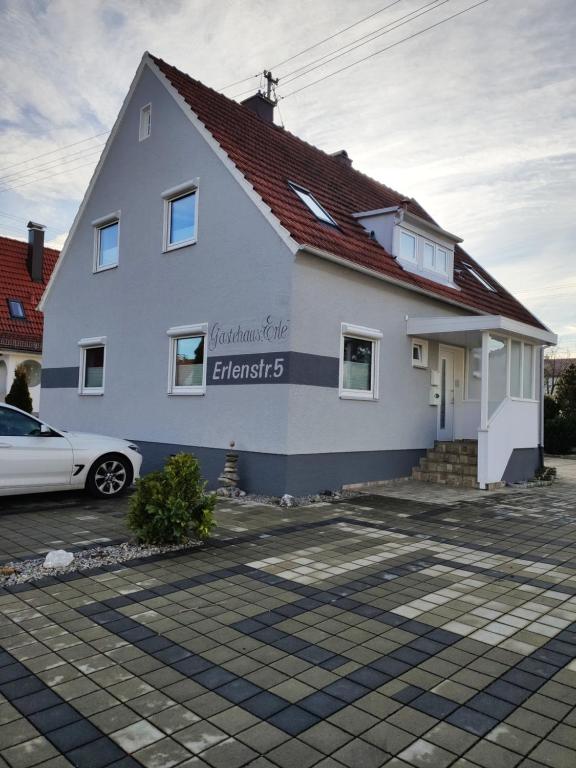 a white house with a car parked in front of it at Gästehaus Erle in Memmingen